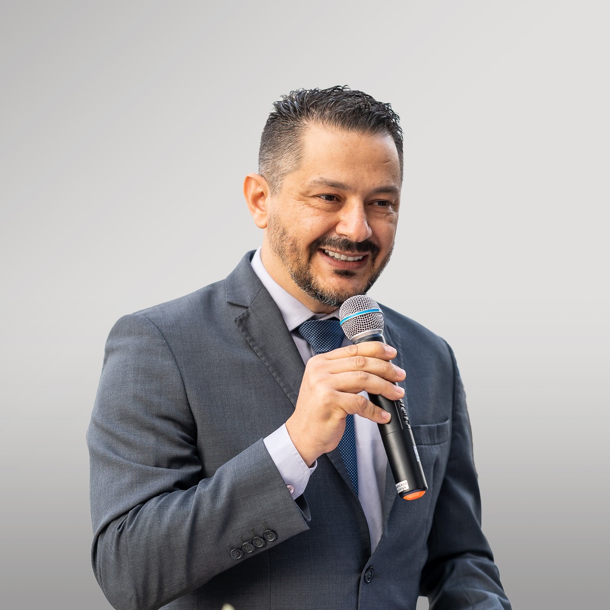 Aleksandro Montanha de terno, falando ao microfone